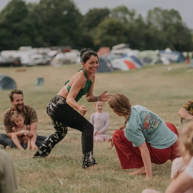 Two participants playfully interacting in a dynamic movement activity during an outdoor group session.
